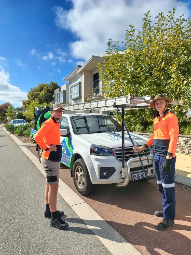 Perth Gutter Cleaning Pros team with their branded ute outside a Perth home